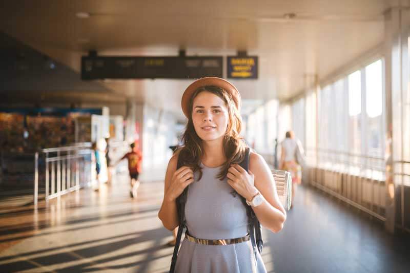 Junge Frau mit Rucksack am Flughafen